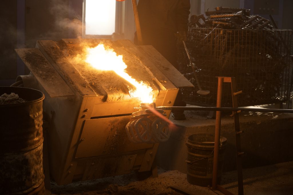 molten metal pouring into ceramic mold in investment casting process