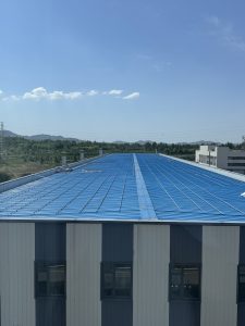 Aerial view of a sustainable investment casting foundry with 5,000 sqm solar panels on factory roof. Green casting powered by renewable energy for low carbon manufacturing and carbon footprint reduction.